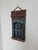 A wonderfully distinctive signed Brazilian carved wood wall sculpture dating to 1979, depicting a colorful architectural...