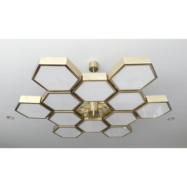 Impressive Italian chandelier with 12 hexagonal glossy white glass diffusers, mounted on thick hexagonal brass cells in...