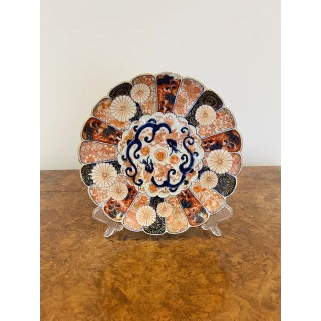 Quality antique Japanese imari plate with a scalloped shaped edge having hand painted panels to the outside with flowers...