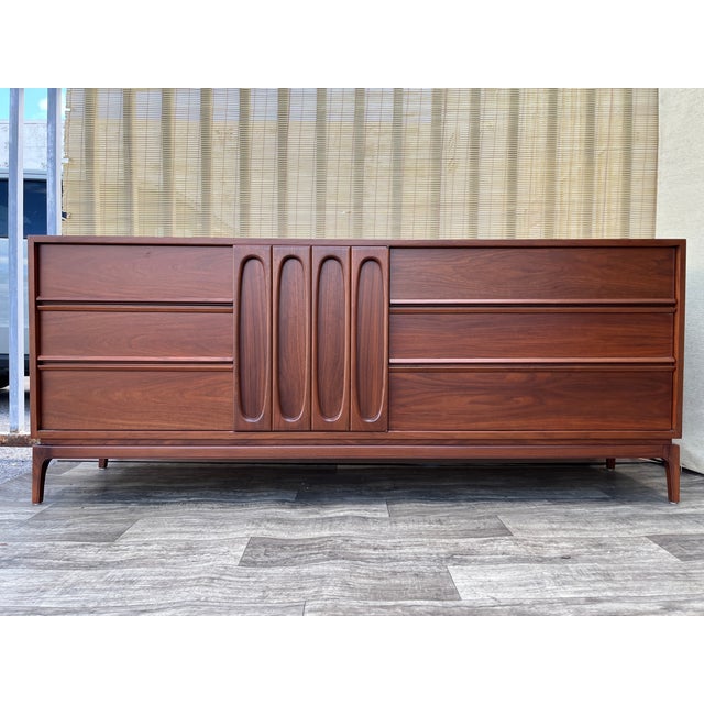 Newly Refinished Mid-Century Modern Sculptural 9-Drawers Dresser. Circa 1960s. Features a monumental look with a...