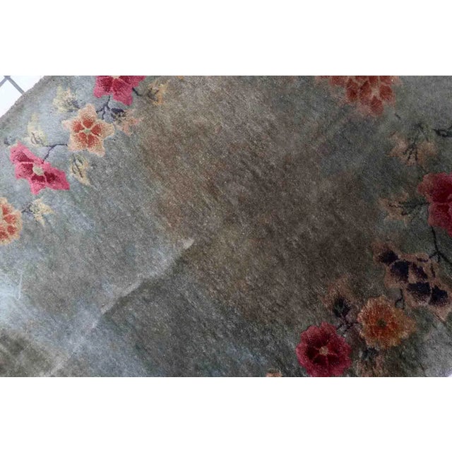 Handmade antique Art Deco Chinese rug in green color and floral design. The rug is from the end of 20th century in...