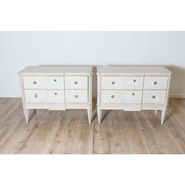 A classic pair of Gustavian-style chests of drawers crafted from solid pine and featuring a distinctive broken-front...