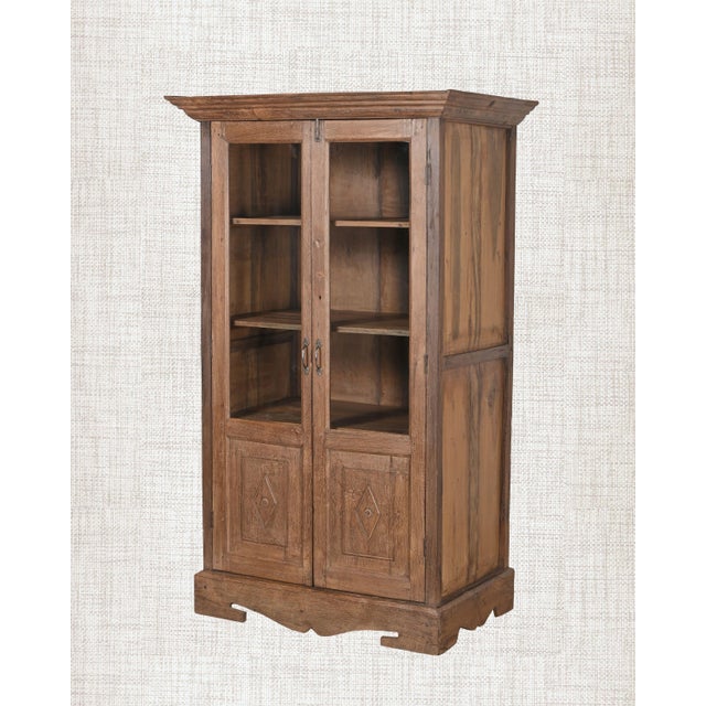 The arched glass panels in the upper doors are what stop you first. Then the ornate brass latches. Then you notice the...