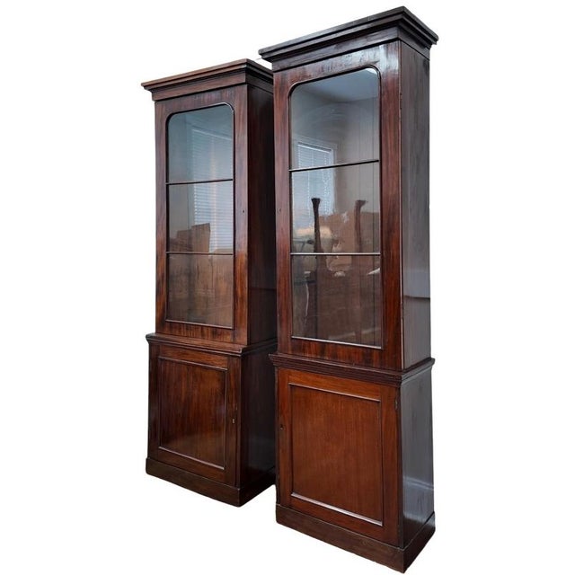 A striking and unusually tall pair of opposing mahogany display cabinets, measuring an impressive 8 feet in height. Though...
