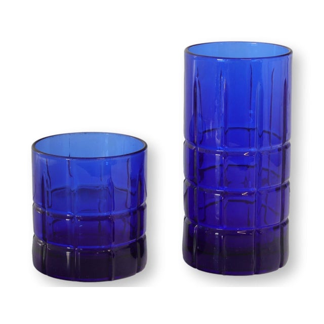 Mid 20th century Anchor Hocking Tartan pattern glassware in vivid cobalt blue. This 15-piece grouping includes eight tall...