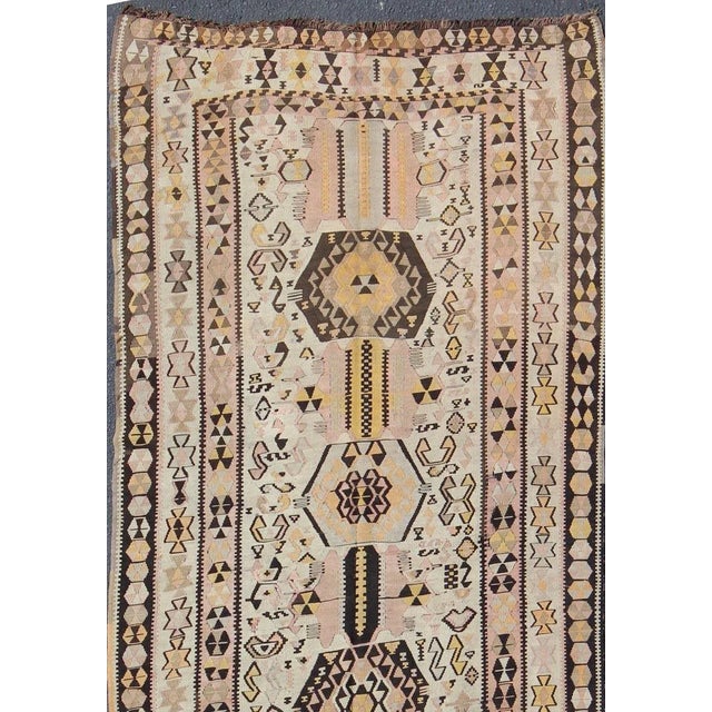 This vintage Turkish Kilim gallery rug (circa mid-20th century) features a unique blend of colors and an intricately...