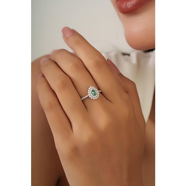 This cocktail ring features a 0.2 carat pear-shaped emerald set in 18k white gold. The emerald measuring 3.2 x 5 mm,...