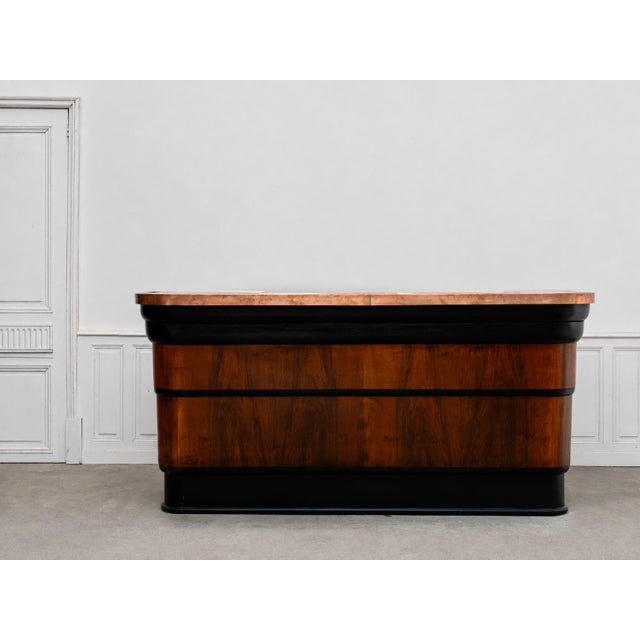A rare 1960s bar counter combining a dark oak frame with elegant copper cladding. Its rounded lines and beautiful...