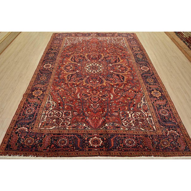 An authentic vintage traditional Heriz rug hand-knotted with fine wool and natural dyes. This rug features a central...