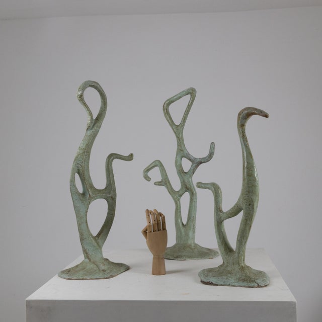 Description Set of three papier-mâché sculptures featuring elongated organic forms. Textured light green finish with an...