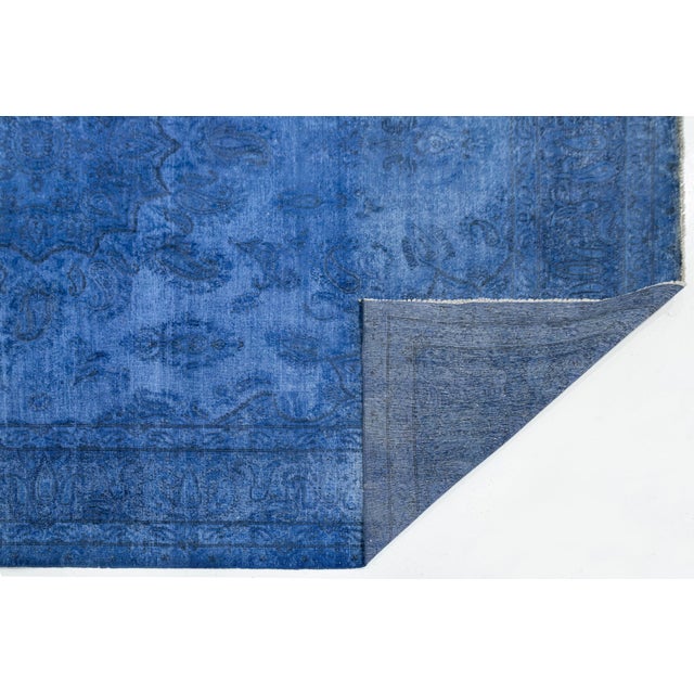 Revitalize your space with this stunning vintage Persian wool rug, overdyed in a vibrant electric blue. It beautifully...