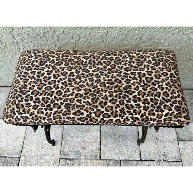 Vintage bench that is constructed from a patinated metal base (likely cast iron or bronze) and is paired with an animal...
