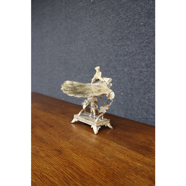 Ornate Victorian silver-plated tazza featuring a pierced figural framework with cherub figures, scrolling branches,...