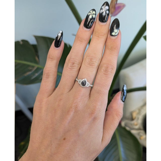A pear-shaped natural alexandrite takes center stage in this solid 14K white gold ring, encircled by a lavish halo of...