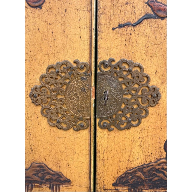 Here is a fabulous mid-century Chinoiserie cabinet featuring a warm yellow ground framed in deep olive green and richly...