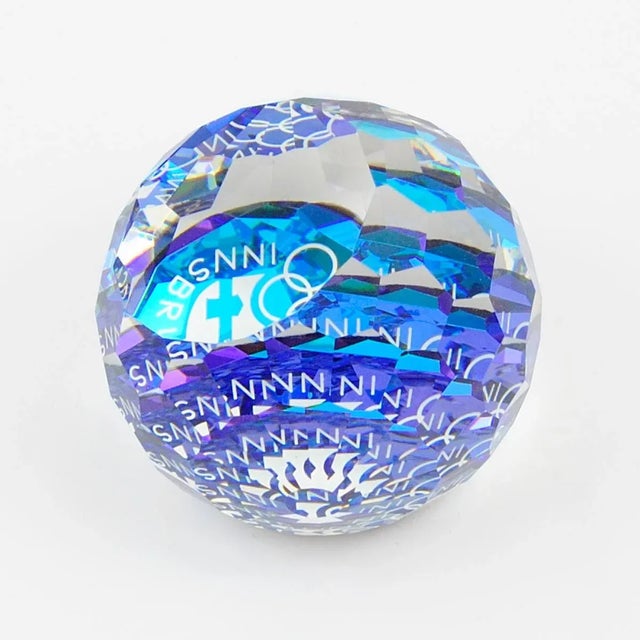 This multi-faceted crystal sphere paperweight was made by Swarovski to commemorate the 1976 Winter Olympics in Innsbruck....