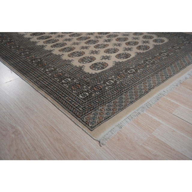 A hand-knotted wool rug, made in India and measuring 4' x 6'. Floral drawing carried across the field inside a traditional...