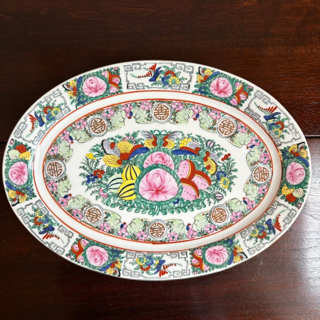 Offering a lovely Famille Rose Chinese export porcelain platter from the mid-20th century. This beautiful oval platter...