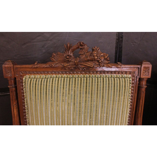 Pair of Louis XVI style fauteuils, French, circa 1860-80. Napoleon III. Of richly carved walnut. Turned, tapered, reeded...