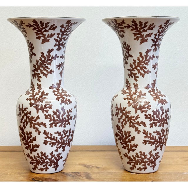Vintage pair of porcelain vases or urns with coral motif. Rich ivory base with wide gilt gold tipped rims and brown coral...