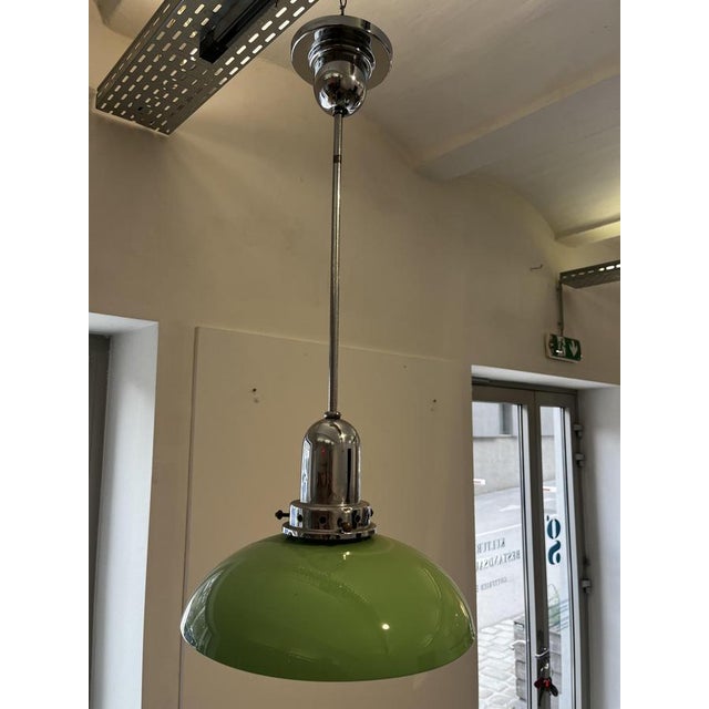 An attractive single-bulb pendant light from the 1960s, with a green glass shade and chrome suspension. The lamp is in...