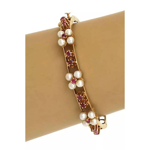 This lovely Estate bracelet is crafted from 14k yellow gold with a polished finish. The front half has 3 sets of 4 pearls...