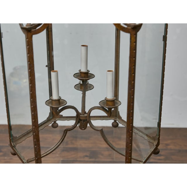 This large French iron lantern from circa 1900 showcases a graceful architectural form crafted from riveted iron with...