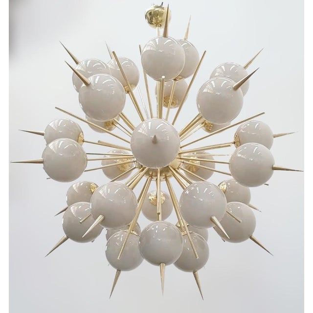 Italian sputnik chandelier with 30 Murano glass globes and solid brass spikes mounted on brass frame in unlacquered...