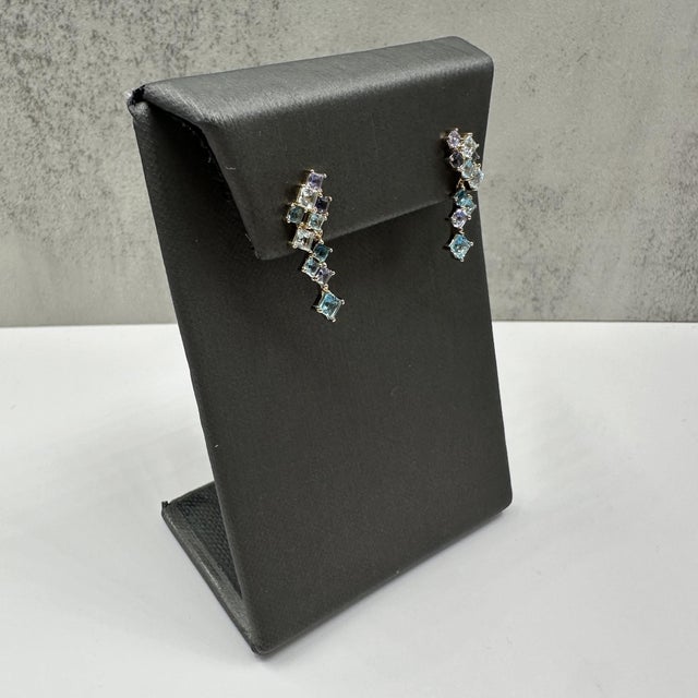 These stunning multicolor blue gemstone dangle earrings in 10kt yellow gold feature approximately 1.75 carats total weight...