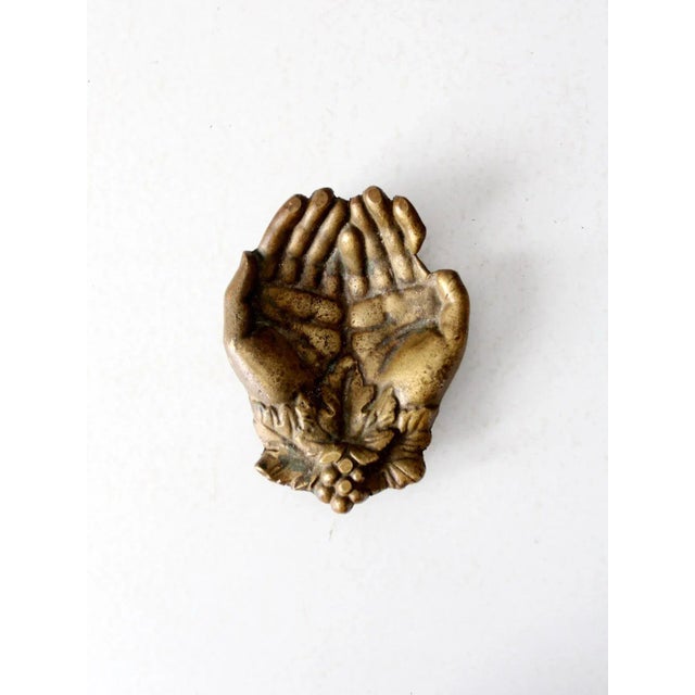 This is a vintage brass sculptural dish. Shaped as two cupped hands, the sculptural bowl makes a great valet tray or...