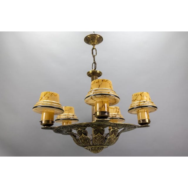 French Art Deco five-light bronze chandelier with marbled beige mushroom glass shades, 1930s. A striking French Art Deco...