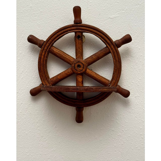 This pair of vintage wooden ship wheel wall shelves feature a classic nautical design, each crafted in the form of a six-...