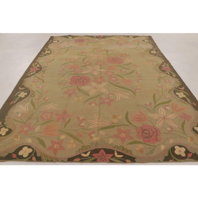 Handmade in wool, this antique hooked rug measures 8x11, circa 1920–1930. The design features a floral medallion design...