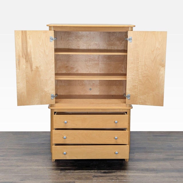 This Huppé hutch and armoire features a clean maple finish, two upper doors with shelves inside for storage, and three...