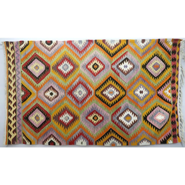 This Turkish Kilim rug hosts an intriguing pallet of vibrant rich and pastel colorways complementing a very turkish sense...