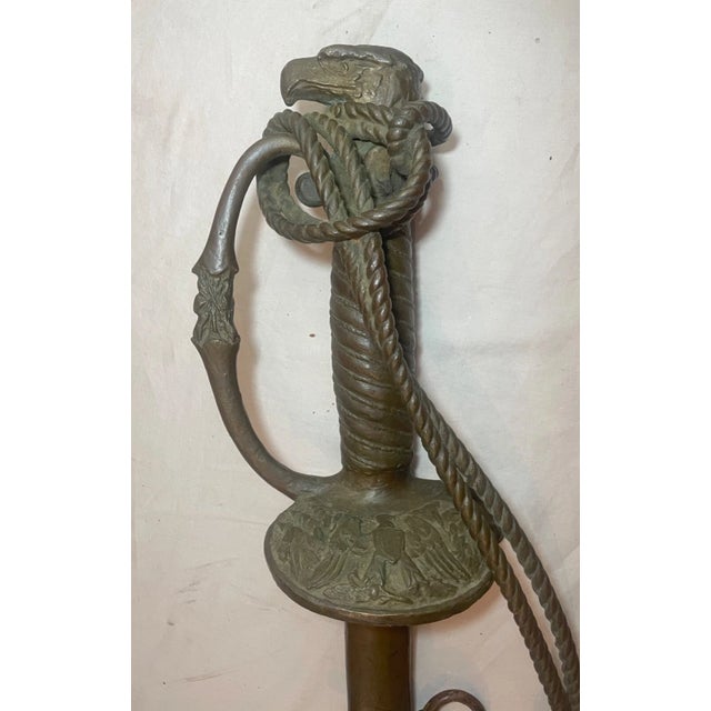 Crafted with meticulous attention to detail, this large antique solid bronze American eagle military sword sculpture is a...