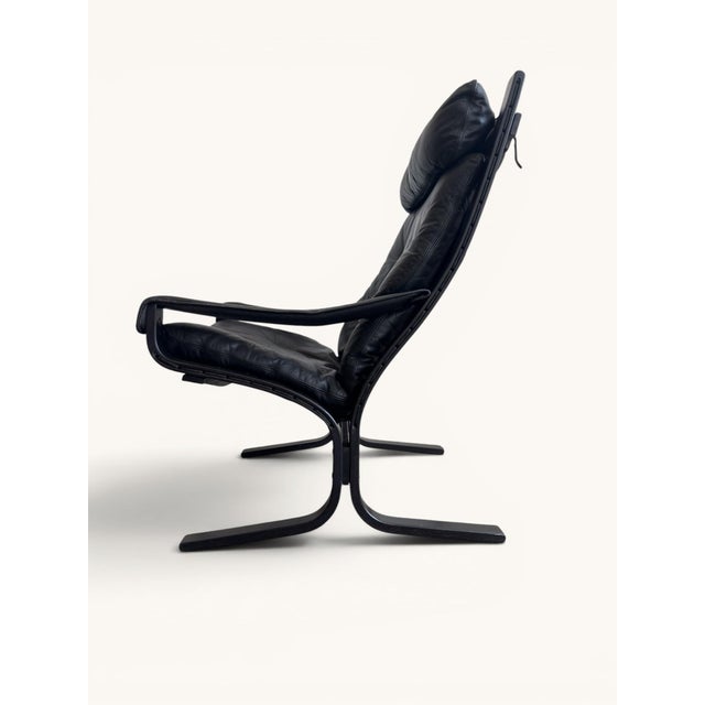 Siesta armchair by Norwegian designer Ingmar Relling. The black leather features a beautiful tufted finish and rests on a...