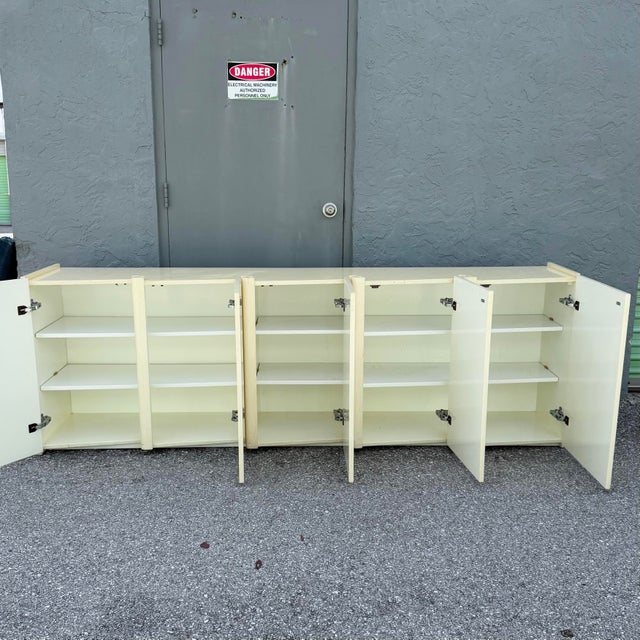 A striking Postmodern credenza showcasing a sculptural sawtooth wave façade in a warm cream woodgrain finish. The clean,...