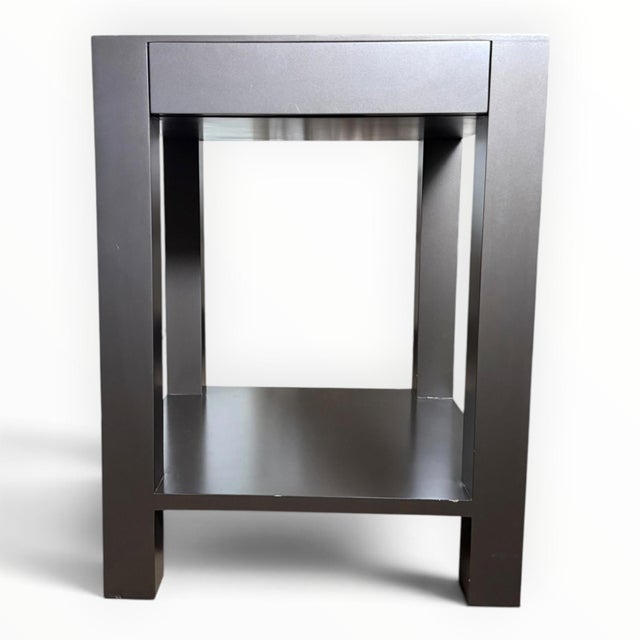 A pair of bedside side tables or nightstands. Parsons-style, each with a single drawer and lower shelf. Solid wood with a...