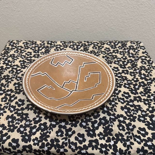 This striking decorative plate features bold, angular designs that blend traditional hand-building techniques with a...