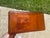 The product is a vintage burnt orange acrylic Wil-Hold sewing box storage unit, made by Willson MFG CORP. designed for...