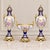 Elegant three-piece French-style garniture set featuring two matching covered porcelain vases and a coordinating central...