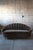 An Italian mid century modern clam shell sofa with a striking silhouette. The arched channel back and curved seat are...