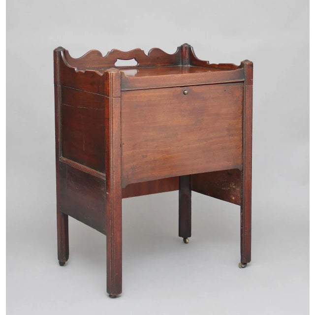 This 18th century mahogany bedside cupboard features a lift-up hinged top. The front of the cupboard has a panel which...