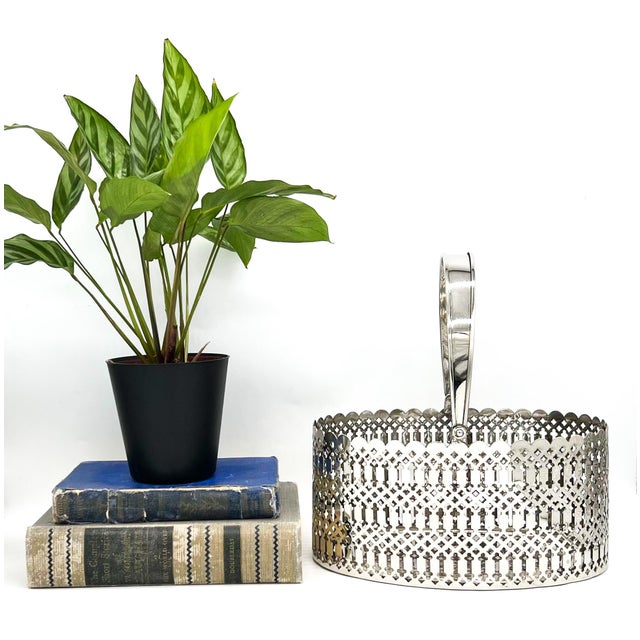 Elegant, late 20th century silver-plated basket featuring an oval silhouette, scalloped rim, and intricate pierced sides...