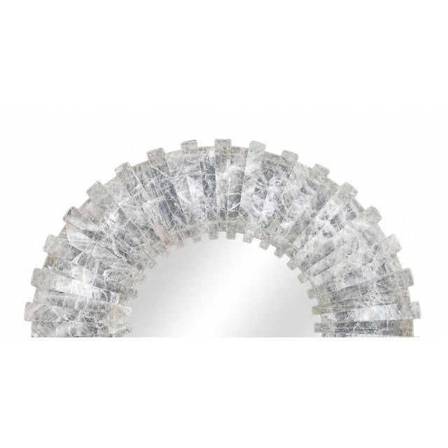 Striking early 21st century sunburst mirror featuring an elaborate rock crystal frame with dramatic dimensional texture...