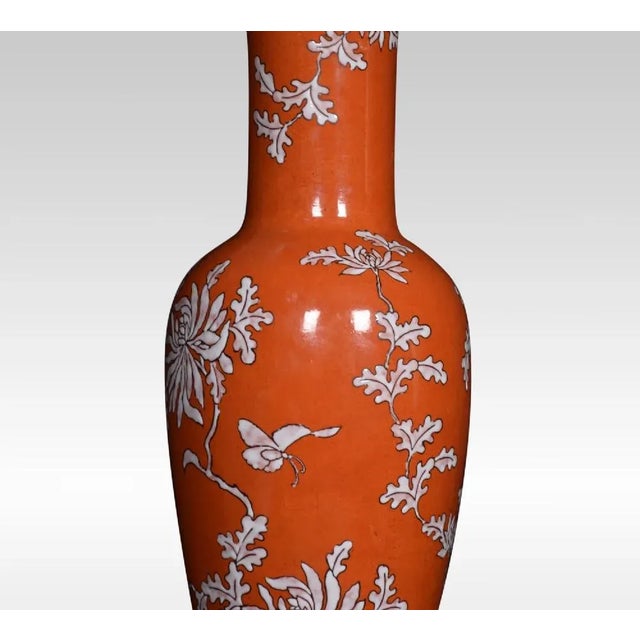 A Chinese baluster form table lamp, with red ground and floral vines, raised on a turned pierced base. Together with...