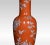 A Chinese baluster form table lamp, with red ground and floral vines, raised on a turned pierced base. Together with...