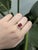 Designed to stand out, this 2.6-carat emerald-cut ruby ring features a rich red center stone accented by earth-mined round...