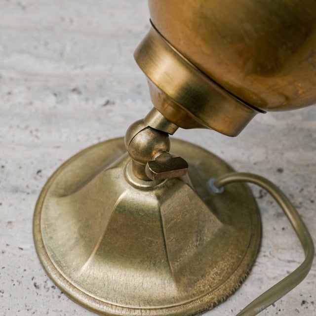 This adjustable spotlight table lamp is representative of the functional and elegant design of the mid-20th century. Its...